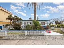 Charming beach house with white picket fence, blue trim, and lush tropical landscaping at 370 Hartford Ave, Daytona Beach, FL 32118