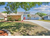 Charming light blue two-story home with brick accents and a vibrant red front door at 4133 Staffordshire Dr, Lakeland, FL 33809