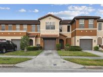 Charming townhome featuring a two-car garage, neutral stucco, and a well-manicured lawn at 6109 Apollos Corner Way, Orlando, FL 32829