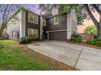 Two-story home with brown siding, white trim, attached two-car garage and concrete driveway at 1300 Holly Glen Run, Apopka, FL 32703