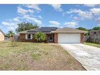 Charming brick home with solar panels, a well-maintained lawn, and a two-car garage at 820 Lamp Post Ln, Lakeland, FL 33809