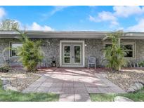 Inviting front entrance with double doors, gray walls, and small tropical plants, giving the home character at 430 Alturas Babson Park Cutoff, Lake Wales, FL 33859