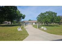 Stunning exterior view of home with a long driveway and lush landscaping at 6975 Sw 99Th St, Ocala, FL 34476