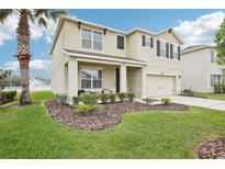 Charming two-story home with a well-manicured lawn and beautiful landscaping at 3387 Tawny Grove Pl, Lakeland, FL 33811