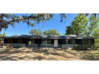 Charming single-story home featuring a freshly painted exterior, well-manicured lawn, and mature shade trees at 3465 Peacock Ln, Mulberry, FL 33860