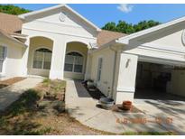 Inviting single-story home featuring arched windows, attached garage, and tidy landscaping at 1184 Athlone Way, Ormond Beach, FL 32174