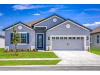 Charming single-Gathering home with a well-manicured lawn and two-car garage on a sunny day at 3319 Chinotto Dr, Lake Alfred, FL 33850