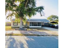 Charming single-story home with a large front tree and a screened-in porch, offering curb appeal at 4746 Wales St, Lake Wales, FL 33859
