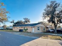 Charming single-story home with a light colored exterior and mature trees providing shade at 2341 Weber St, Lakeland, FL 33801