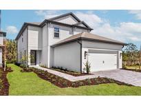 Stunning two-story home with a meticulously maintained lawn, paved walkway, and an attached two-car garage at 7692 Somersworth Dr, Kissimmee, FL 34747