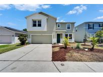 Two-story home boasts a well-manicured front yard with mature landscaping and an attached two-car garage at 2415 Brownwood Dr, Mulberry, FL 33860
