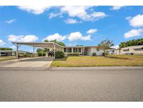 Charming single-story home featuring a carport and a cozy front porch with manicured landscaping and bright white paint at 1610 Reynolds Rd # 353, Lakeland, FL 33801