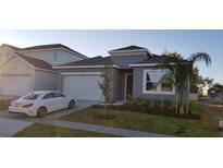 Charming home featuring a two-car garage, well-manicured lawn, and a modern exterior at 753 Grand Hilltop Dr, Apopka, FL 32703