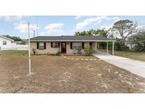 Charming single-story home with neutral paint, black shutters, and a covered carport at 222 Aldo Dr, Babson Park, FL 33827