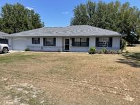 Charming single-story home featuring a well-maintained lawn and neutral exterior at 11757 Se 71St Terrace Rd, Belleview, FL 34420