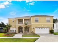 Stunning two-story home featuring a manicured lawn and a two-car garage at 2523 Jasmine Trace Dr, Kissimmee, FL 34758