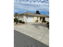 Charming single-story home with an attached two-car garage and a well-manicured lawn at 2807 Leicester Ter, The Villages, FL 32162