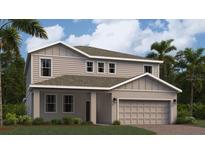 Two-story home boasts a neutral color palette, manicured lawn, two-car garage, and tropical landscaping at 1967 Rider Rain Ln, Apopka, FL 32703