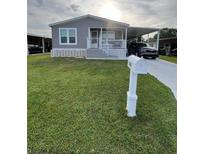 Charming single-story home featuring a carport and well-maintained lawn at 118 Jana Cir, Auburndale, FL 33823