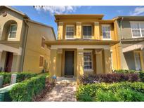 Charming two-story townhome featuring a covered entryway and neatly landscaped front yard at 7752 Moser Ave, Windermere, FL 34786