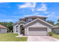 Charming two-story home with a two car garage and well-manicured lawn at 2433 Huron Cir, Kissimmee, FL 34746