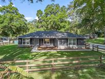 Charming single-story home featuring a well-manicured lawn and a rustic wooden fence at 5434 Se 39Th Ave, Ocala, FL 34480