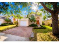 Charming two-story home with a brick paved driveway, well-manicured lawn, and mature landscaping at 1142 Mariner Cay Dr, Haines City, FL 33844