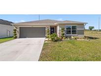 Charming single-story home with a well-manicured lawn and a two-car garage at 1065 Mattie Pointe Way, Auburndale, FL 33823