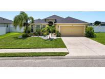 Well-maintained home featuring a manicured lawn and tropical landscaping at 4662 Harts Brook Ln, Mulberry, FL 33860