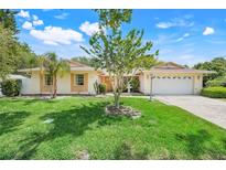 Charming single-story home with manicured lawn, mature trees, and a welcoming two-car garage at 1604 Nottingham Dr, Winter Park, FL 32792