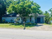 Charming single-story home featuring a well-manicured lawn and a large tree providing shade, perfect curb appeal at 208 Shepard Ave, Dundee, FL 33838