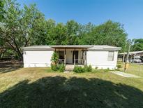 Charming single-story home with a covered porch and a well-maintained front yard and mature landscaping at 6702 Brookridge Trl, Lakeland, FL 33810