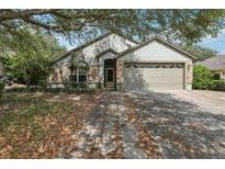 Charming single-story home with stone accents, mature landscaping, and a two-car garage at 30653 Pga Dr, Sorrento, FL 32776