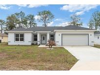 Charming single-story home features a welcoming front yard, attached garage, and newly painted exterior at 14404 Sw 19Th Pl, Ocala, FL 34481