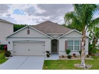 Charming single-story home with a two-car garage, lovely landscaping, and a welcoming front entrance with beautiful flowers at 3205 Royal Tern Dr, Winter Haven, FL 33881
