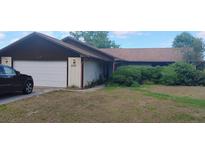 Charming single-story home featuring an attached garage and well-maintained landscaping at 9873 County Road 114B, Wildwood, FL 34785