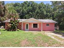 Charming single-story home featuring a quaint front porch and a classic design surrounded by trees at 11305 Sw 186Th Cir, Dunnellon, FL 34432