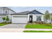 Charming single-Gathering home boasts stone accents, a well-manicured lawn, and an attached two-car garage at 5914 Bristle Oak St, Mount Dora, FL 32757