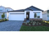 Charming single-Gathering home featuring a well-manicured lawn and a paved driveway leading to an attached two-car garage at 5914 Bristle Oak St, Mount Dora, FL 32757