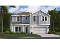 Charming two-story home featuring a light gray exterior, well-manicured lawn and attached two car garage at 463 Puma Loop, Groveland, FL 34736