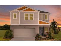 Two-story home featuring a two-car garage, gray siding, and a cozy front porch at 1752 Frogmore Ave, Haines City, FL 33844
