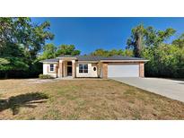 Charming single-story home featuring brick accents, attached two-car garage, and a well-maintained lawn at 210 Alta Vista St, Debary, FL 32713