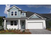 Charming two-story home with a blue accent and attached two-car garage at 6069 Sacred Oak Ave, Mount Dora, FL 32757