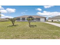 Charming single-story home with a well-maintained lawn and driveway on a beautiful sunny day at 326 Marion Oaks Trl, Ocala, FL 34473