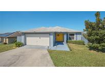 Charming single-story home with a well-manicured lawn and a bright yellow front door at 612 Chicago Way, Dundee, FL 33838