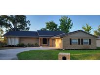 Charming brick home featuring a well-manicured lawn and a driveway leading to a welcoming entrance at 1524 New Jersey Oaks Ct, Lakeland, FL 33801