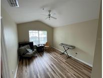 Bright living room featuring wood floors, a ceiling fan, and plenty of natural light from the window at 6059 Twain St # 108, Orlando, FL 32835