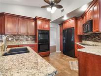 Modern kitchen boasting granite countertops, tile backsplash, stainless steel appliances, and custom cabinetry at 994 Country Lake Cir, Lake Wales, FL 33898
