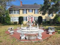 Charming two-story home with a front fountain and a landscaped yard at 800 W Lake Elbert Ne Dr, Winter Haven, FL 33881