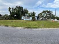 A blue single-Gathering home with a fenced-in yard, surrounded by lush trees, sits on a corner lot at 5137 Polaris St, Orlando, FL 32819